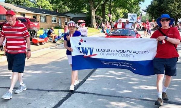 League of Women Voters of Wayne County members carrying the organization's banner while walking in a parade.